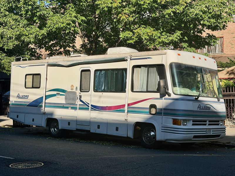 Late-1990s Class A motorhome parked on a city street